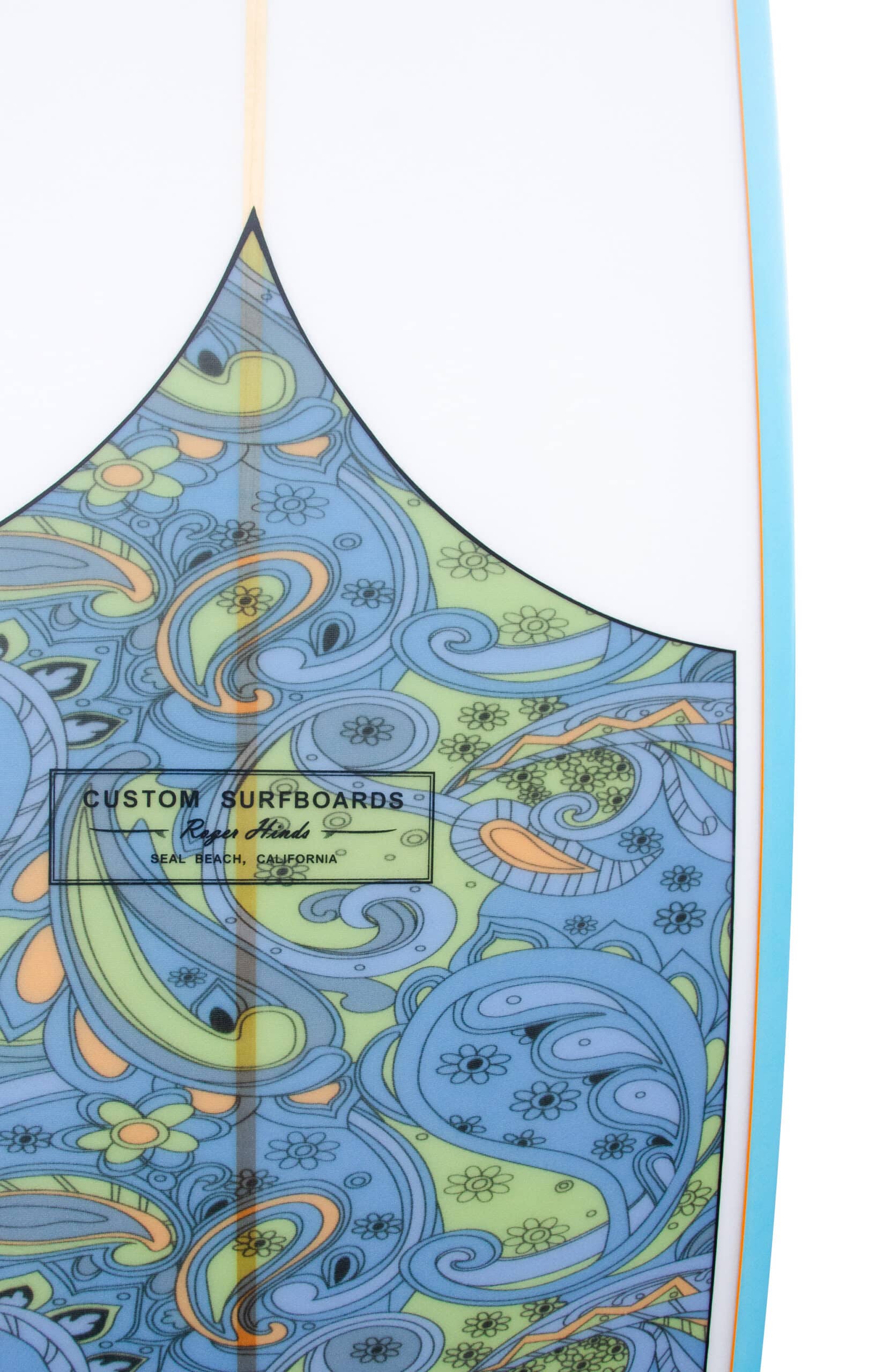 Shapers-Club- A close-up view of Roger Hinds' surfboard - Tamago 7'6" x 22" x 2' 7/8" features a colorful abstract pattern in shades of blue, green and yellow. The intricate design features wave and floral elements. A label on the surfboard reads "Custom Surfboards. -surfshop-surfboard