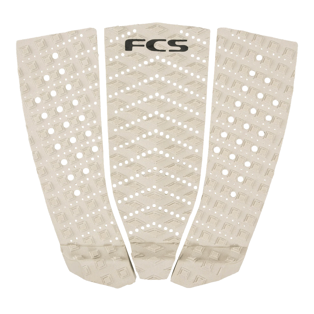 Shapers-Club- The PAD - TRACTION ECO BLEND T3 is a beige traction pad with three textured sections, each adorned with diamond patterns and small circular cut-outs. Made from ECO BLEND T3 material, the top section prominently features the words "FCS" in black lettering. -surfshop-surfboard